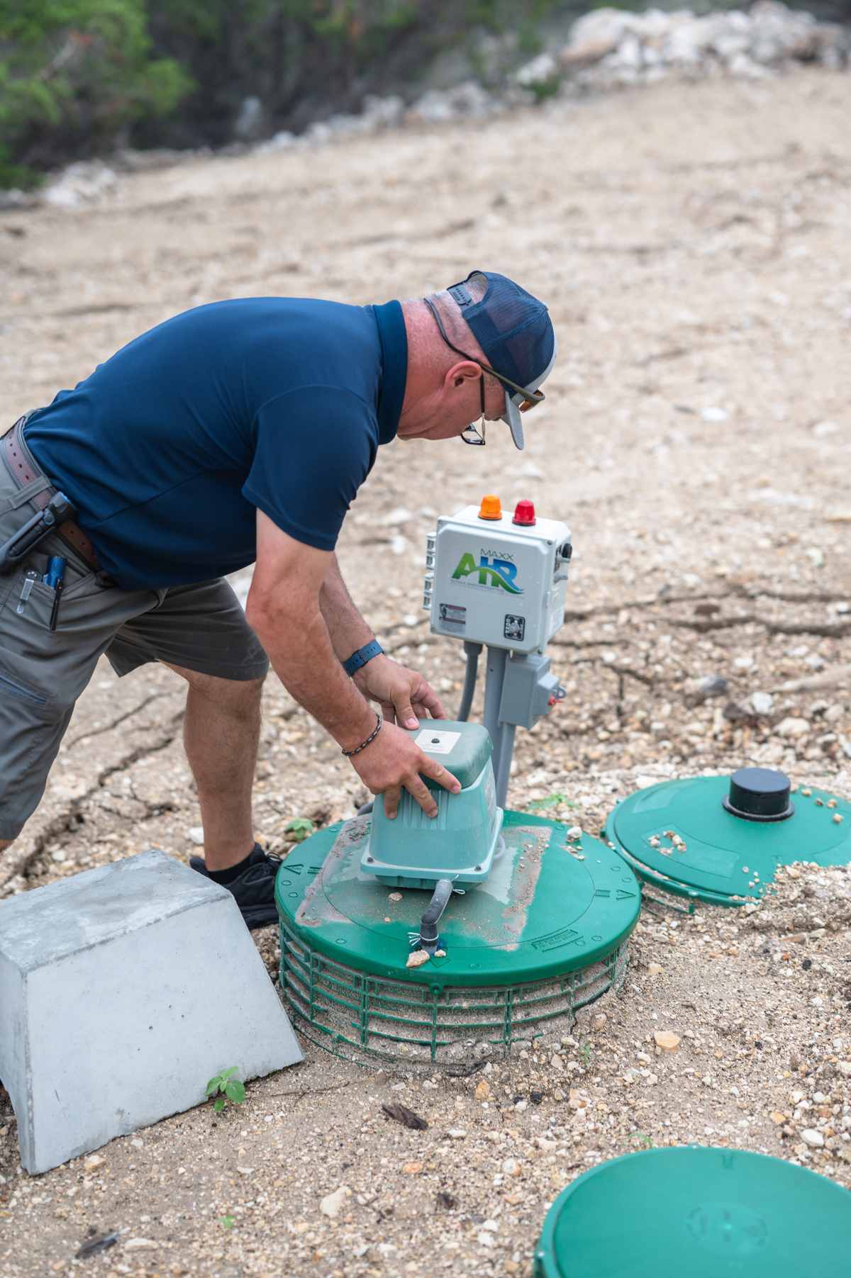 Inspector checking the aerator and control panel on an aerobic septic system